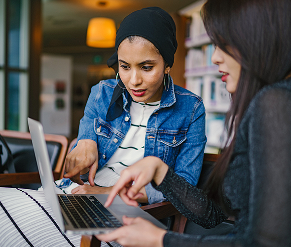 Two young women looking at the computer screen